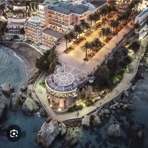 een luchtzicht op een resort met palmbomen en de oceaan bij El balcón de Nerja in Nerja