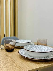 a wooden table with three plates and bowls on it at SMDC CHARM 1 bedroom condo with Netflix & Balcony in Manila +6 photos