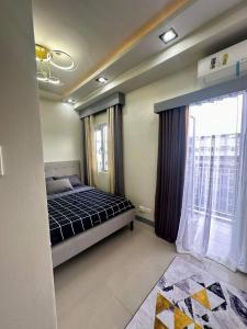 a bedroom with a bed and a large window at SMDC CHARM 1 bedroom condo with Netflix & Balcony in Manila