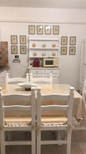 a kitchen with a table with chairs and a microwave at APPARTAMENTO LIDO 1 in Alghero
