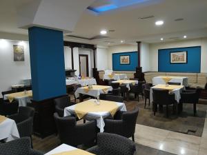 ein Esszimmer mit Tischen und Stühlen und blauen Wänden in der Unterkunft Hotel Viv in Trebinje