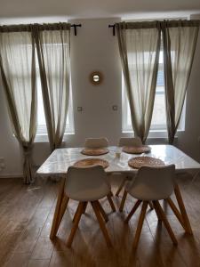 a dining room with a table and four chairs at Jolie petite maison in Saint-Vaast
