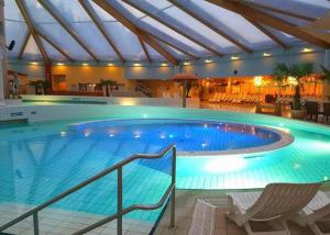 a large swimming pool in a hotel with a ceiling at Hotel & Café Mohrenbrunnen in Eisenberg