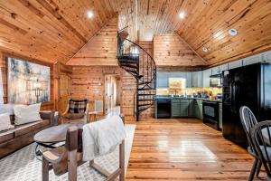 a kitchen and living room with a spiral staircase in a cabin at Pvt Pool at The Grotto in Sevierville