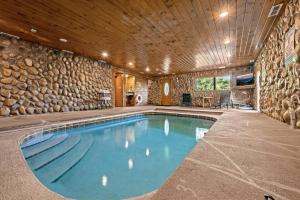 a swimming pool in a house with a stone wall at Pvt Pool at The Grotto in Sevierville