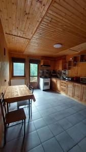 a kitchen with a wooden ceiling and a table and chairs at Villa Gold in Yaremche