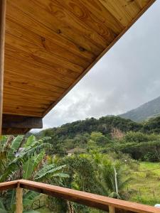 a wooden porch with a view of a mountain at Chalés das Acácias in Sana