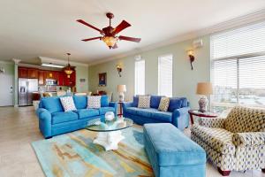sala de estar con sofás azules y ventilador de techo en Dolphin Point 702A, en Destin