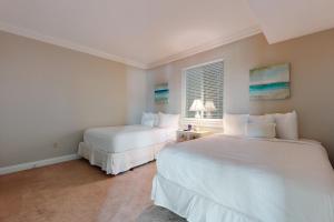 Un dormitorio con dos camas y una ventana. en Dolphin Point 702A, en Destin