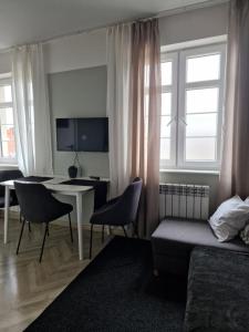 a bedroom with a desk and a bed and a table at Loft Rooms - Apartamenty w Kamienicy centrum, bezpłatny parking in Ełk