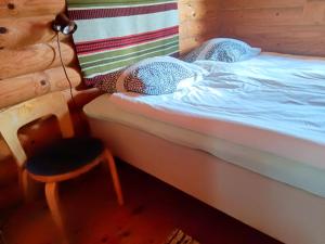 a small bed with a chair in a room at Velkuanmaa Lomamökki in Naantali +21 photos
