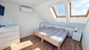 a small bedroom with a bed and two windows at Wysoka Fala in Jastrzębia Góra