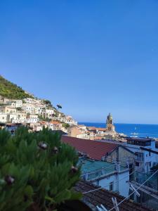 a group of buildings on a hill next to the ocean at #goldenhour in Amalfi
