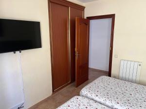 a bedroom with a bed and a flat screen tv at Apartamento Rey I in Valencia