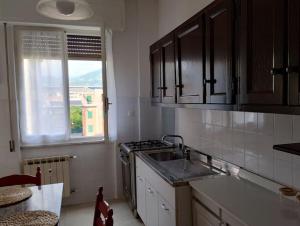 a kitchen with a sink and a stove and a window at Casa Morgana in Chiavari
