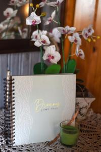 a book sitting on a table with a vase with flowers at Harzglück in Thale +28 photos