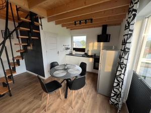 a small kitchen and dining room with a table and chairs at Domek nad jeziorem Raduńskim in Borzestowska Huta