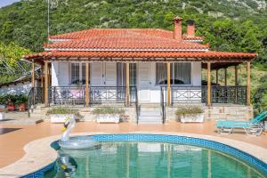 a swan in a pool in front of a house at VILLA MITZELOS in Skiathos