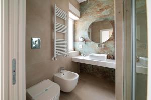 a bathroom with a toilet and a sink and a mirror at Casa Cescal Rooms in Vieste +50 photos
