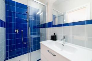 a blue tiled bathroom with a sink and a shower at Comfort Zone - Amalfi Coast in Maiori
