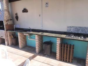 a outdoor kitchen with a counter and a sink at Studio completo ar e piscina in Palhoça