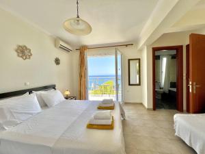 sypialnia z dużym łóżkiem i widokiem na ocean w obiekcie Villa Sakos Skala Kefalonia w mieście Skála Kefalonias +35 zdjęć