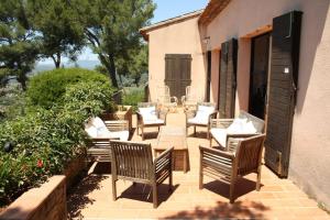 un patio con un montón de sillas y una mesa en Superbe villa Calista classée 5 Etoiles pour 10 personnes avec piscine vue mer, proche des plages et du Circuit du Castellet Paul Ricard, en Le Beausset