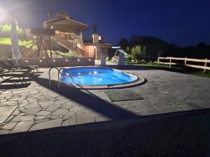 a swimming pool in a backyard at night at Kuća sa bazenom za odmor i domjenke MARIS in Gornji Kraj