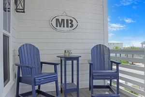 dos sillas azules y una mesa en un porche en Biggies Beach House by Pristine Properties Vacation Rentals, en Mexico Beach