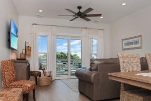 Una sala de estar con un sofá y un ventilador de techo. en Biggies Beach House by Pristine Properties Vacation Rentals, en Mexico Beach