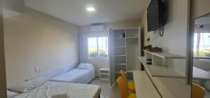 um pequeno quarto com uma cama e uma janela em Marinas de Tamandaré 102 em Tamandaré