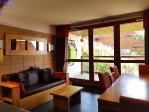 a living room with a couch and a table at Résidence Roc Belleface C - Appartement 3 pièces 8 personnes à Arc 1600 à côté des pistes et des commerces, avec accès gratuit à la piscine et au sauna de MAE-3194 in Arc 1600