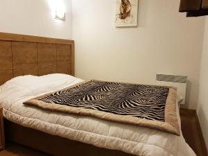 a bed with a zebra blanket on top of it at Résidence Roc Belleface C - Appartement 3 pièces 8 personnes à Arc 1600 à côté des pistes et des commerces, avec accès gratuit à la piscine et au sauna de MAE-3194 in Arc 1600