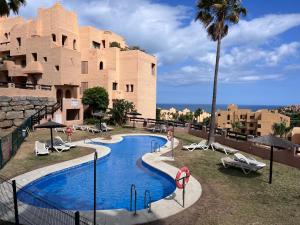 a resort with a swimming pool in front of a building at Oasis Coto Real apartments in San Luis de Sabinillas