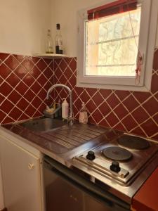 a kitchen with a stove and a sink and a window at STUDIO INDEPENDANT AUBAGNE proche AIX CASSIS LA CIOTAT MARSEILLE in Aubagne +12 photos