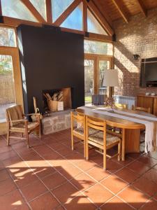 una sala de estar con una mesa y una chimenea en La Bignonia Posada, en Chacras de Coria