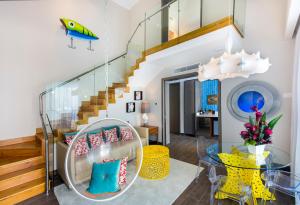 a living room with a staircase and a glass table at Nickelodeon Hotels & Resorts Punta Cana - Gourmet All Inclusive by Karisma in Punta Cana