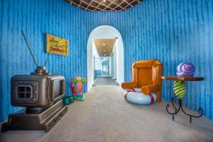 a room with a tv and a blue wall at Nickelodeon Hotels & Resorts Punta Cana - Gourmet All Inclusive by Karisma in Punta Cana