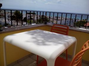 a white table and chairs on a balcony at B&B Lu Cantoru in Marina di Pescoluse