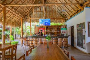 a bar in a restaurant with wooden tables and chairs at Hotel Ingigante in Rivas
