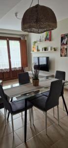 Una mesa de comedor con sillas y un televisor. en Apartamento Figueras, en figueras