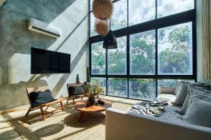 a living room with a couch and a tv at BT Homes - Wellness Jungle in Tulum