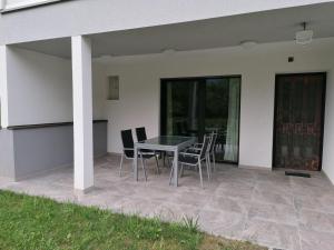 a patio with a table and chairs next to a house at FeWo Kanzianibergblick in Finkenstein