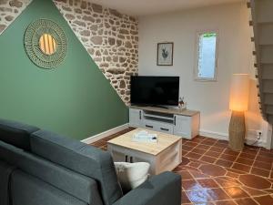 a living room with a couch and a tv at Gîte de l'échappée Saline in Piriac-sur-Mer