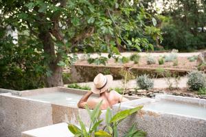 a person sitting in a tub in a garden at Loft de diseño en Masía Rural, Cantallops, Girona in Cantallops
