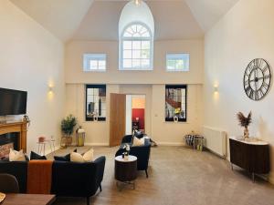 a living room with couches and a clock on the wall at St Mary's Mews in Truro