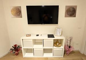 a white cabinet with a flat screen tv on a wall at Lux Beach Apartment GOLD in Lido di Ostia