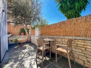 a patio with chairs and a table and a fence at Zace Studios in Ksamil