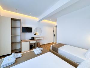a hotel room with two beds and a television at Zace Studios in Ksamil