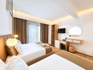 a hotel room with two beds and a desk at Zace Studios in Ksamil